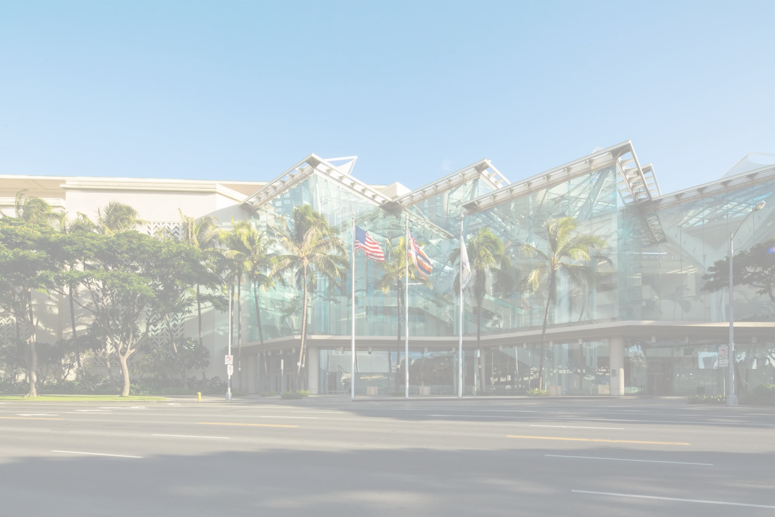 Hawai‘i Convention Center glass exterior with palm trees along Kalākaua Avenue, supported by Smart City Networks for technology services.