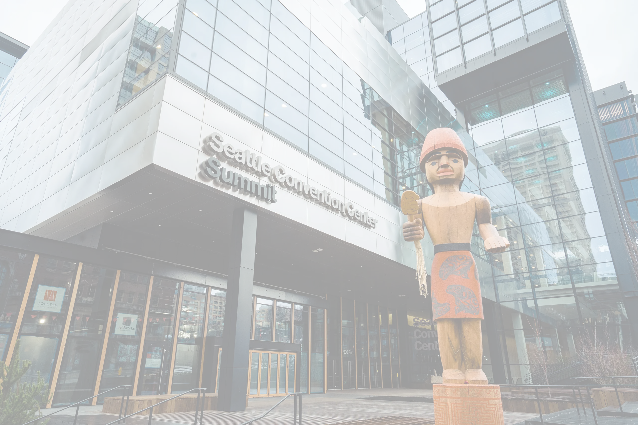 Seattle Convention Center Summit Building exterior with modern glass façade and Native carving, supported by Smart City Networks for connectivity services.
